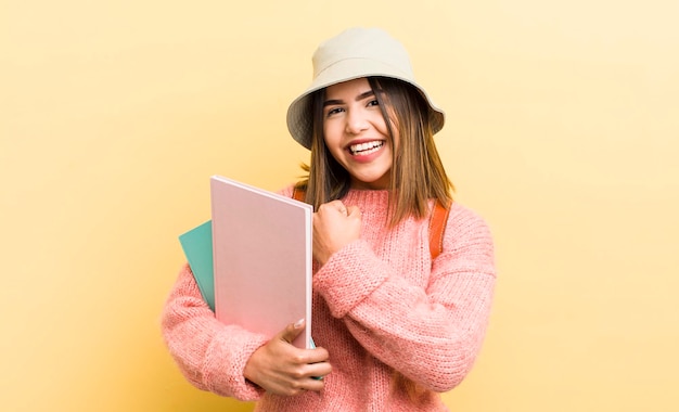 Pretty hispanic girl feeling happy and facing a challenge or celebrating student concept