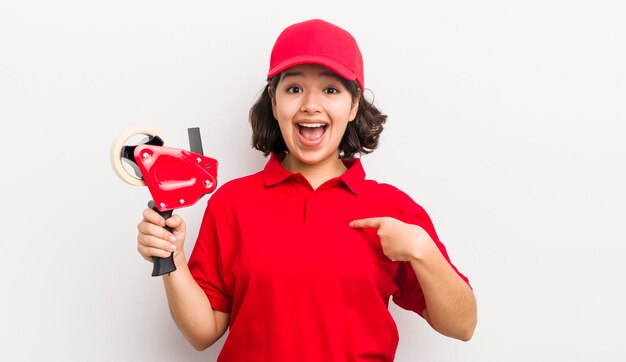 Pretty hispanic girl feeling happy and pointing to self with an excited packer concept