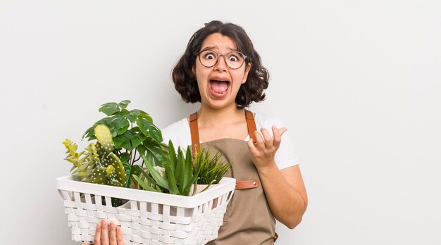 Pretty hispanic girl looking desperate frustrated and stressed plants concept