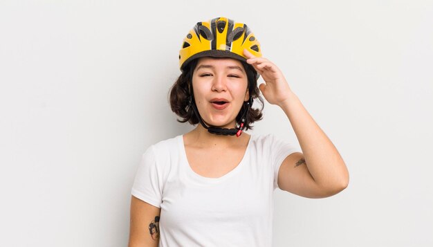 Pretty hispanic girl looking happy astonished and surprised bike concept