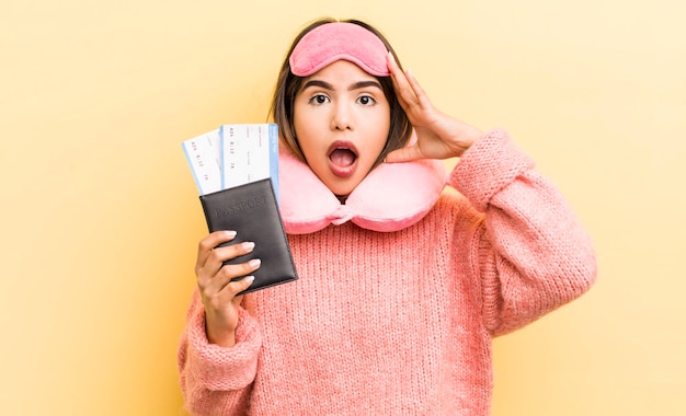 Pretty hispanic girl looking happy astonished and surprised flight passenger concept