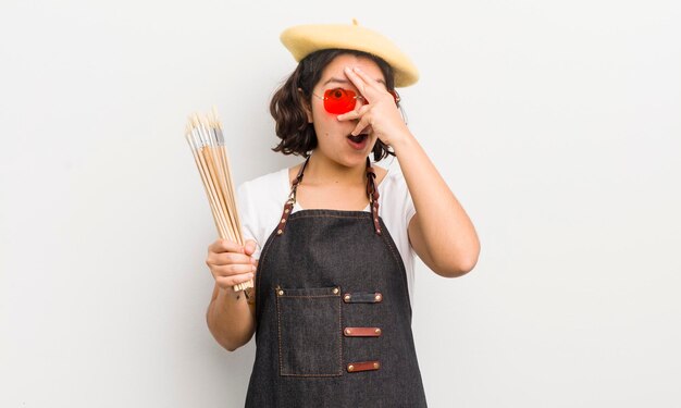 Photo pretty hispanic girl looking shocked scared or terrified covering face with hand art student concept