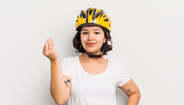 Pretty hispanic girl making capice or money gesture telling you\
to pay bike concept