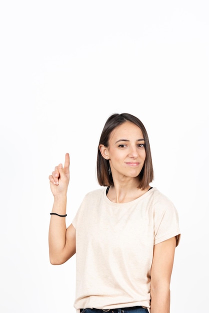 Pretty hispanic girl pointing up to white copy space