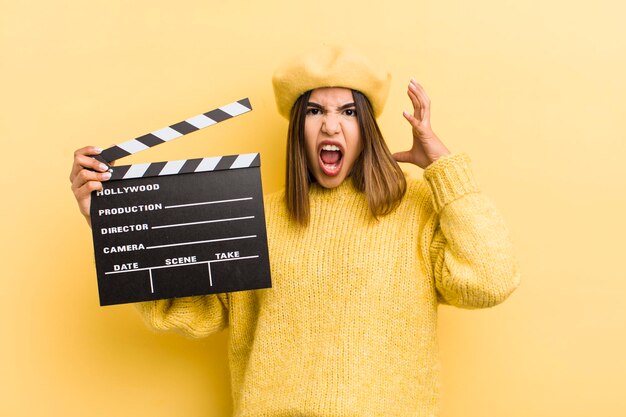 Pretty hispanic girl screaming with hands up in the air cinema concept