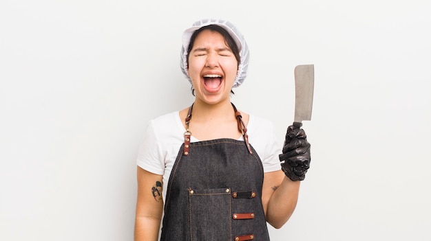 Pretty hispanic girl shouting aggressively looking very angry butcher concept