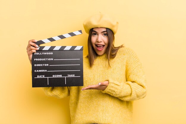 Pretty hispanic girl smiling cheerfully feeling happy and showing a concept cinema concept