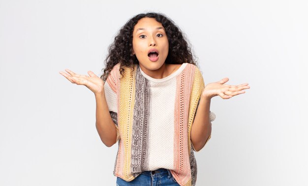 Pretty hispanic woman feeling extremely shocked and surprised, anxious and panicking, with a stressed and horrified look