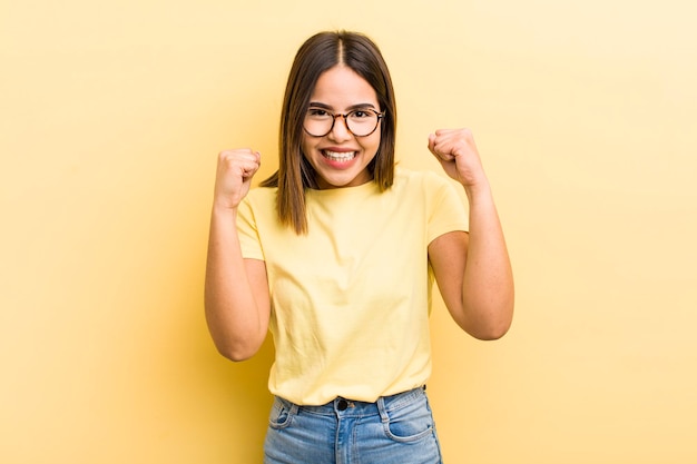 Pretty hispanic woman feeling happy positive and successful celebrating victory achievements or good luck