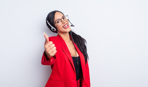 Pretty hispanic woman feeling proud,smiling positively with thumbs up. telemarketing concept