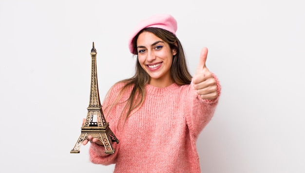 프랑스 개념을 위로 엄지손가락으로 긍정적인 미소를 짓고 있는 예쁜 히스패닉 여성