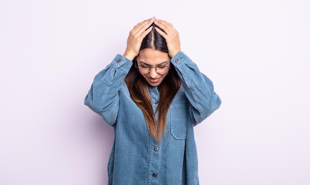 Pretty hispanic woman feeling stressed and frustrated, raising hands to head, feeling tired, unhappy and with migraine