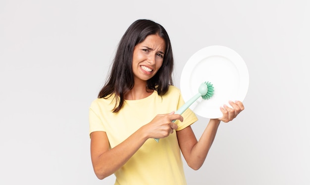 Pretty hispanic woman holding an epty clean dish