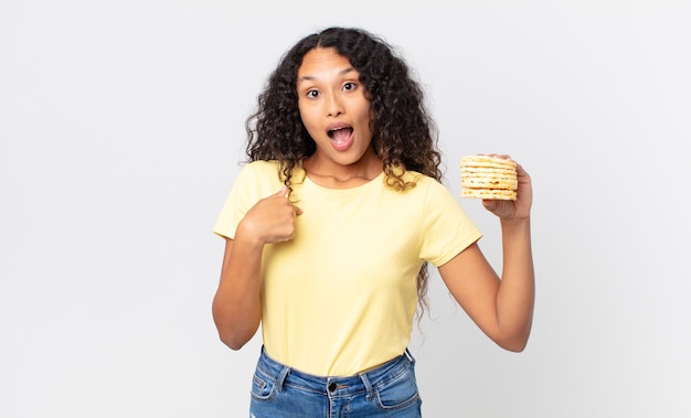 Pretty hispanic woman holding a rice diet cakes