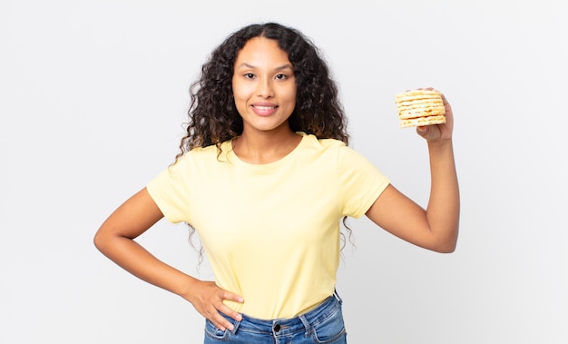 Pretty hispanic woman holding a rice diet cakes