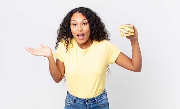 Pretty hispanic woman holding a rice diet cakes