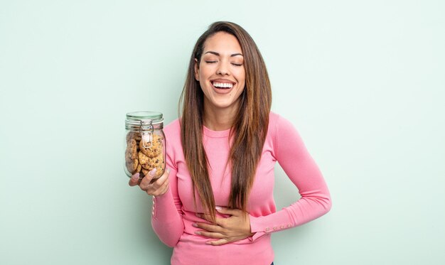 Foto bella donna ispanica che ride ad alta voce per un concetto esilarante di biscotti scherzosi