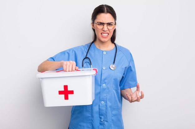 Pretty hispanic woman looking angry annoyed and frustrated nurse and first aid kit