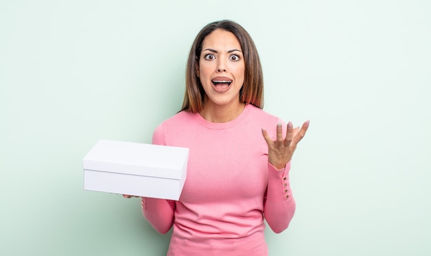 Pretty hispanic woman looking angry, annoyed and frustrated. white box packaging concept