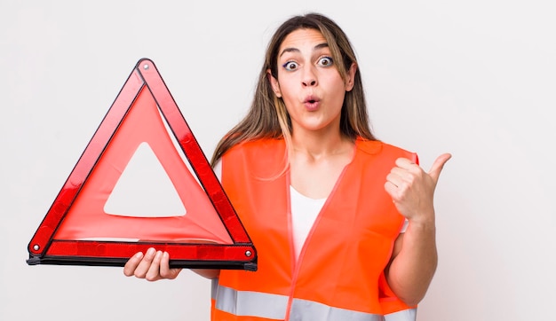 Photo pretty hispanic woman looking astonished in disbelief car triangle concept