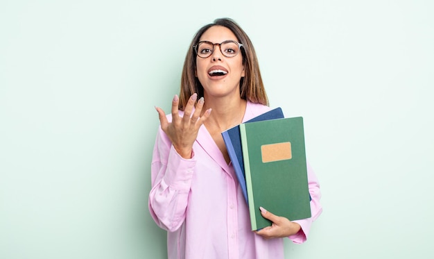 Pretty hispanic woman looking desperate, frustrated and stressed. notebooks concept