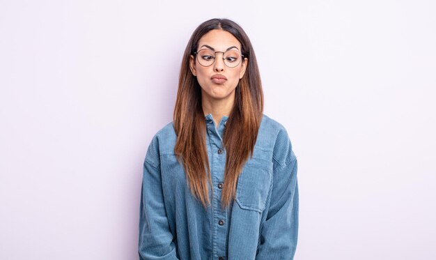 Pretty hispanic woman looking goofy and funny with a silly cross-eyed expression, joking and fooling around