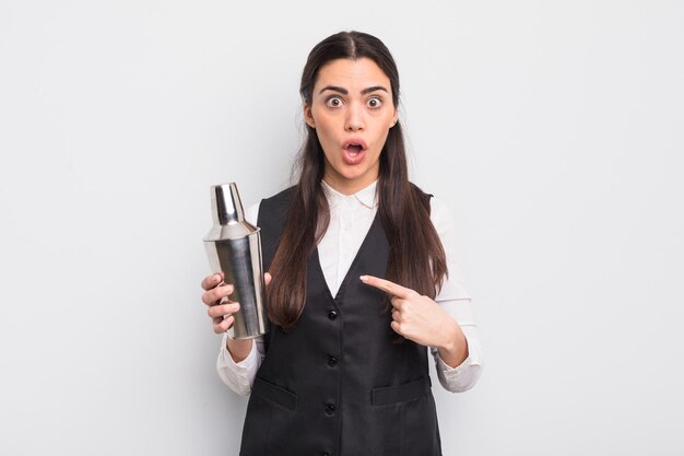 pretty hispanic woman looking shocked and surprised with mouth wide open, pointing to self. barman cocktail concept