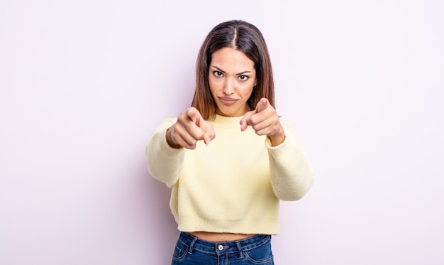 Pretty hispanic woman pointing forward at camera with both fingers and angry expression, telling you to do your duty