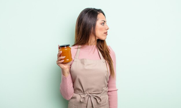 Bella donna ispanica sulla vista di profilo pensando di immaginare o sognare ad occhi aperti il concetto di marmellata di pesche