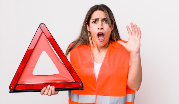 Pretty hispanic woman screaming with hands up in the air car triangle concept