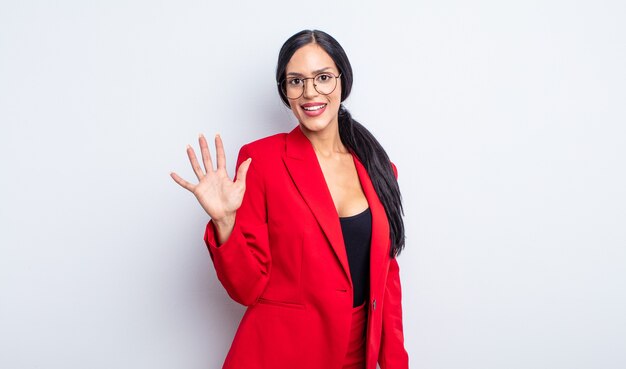 Pretty hispanic woman smiling and looking friendly, showing number five. businesswoman concept