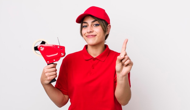 Pretty hispanic woman smiling and looking friendly showing number one packer concept