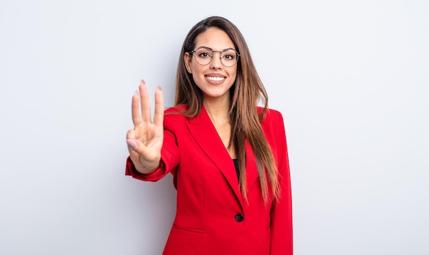 Pretty hispanic woman smiling and looking friendly, showing number three. businesswoman concept