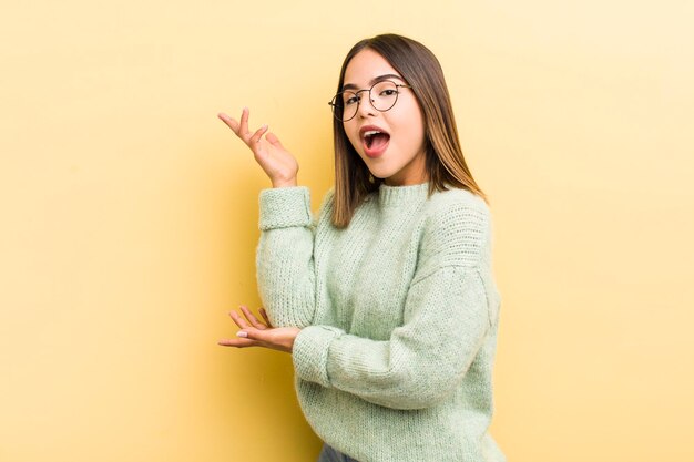 Pretty hispanic woman smiling proudly and confidently feeling happy and satisfied and showing a concept on copy space