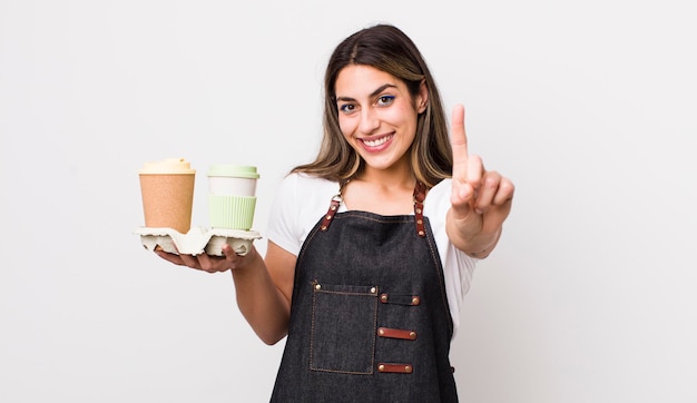 Pretty hispanic woman smiling proudly and confidently making\
number one take away coffee concept