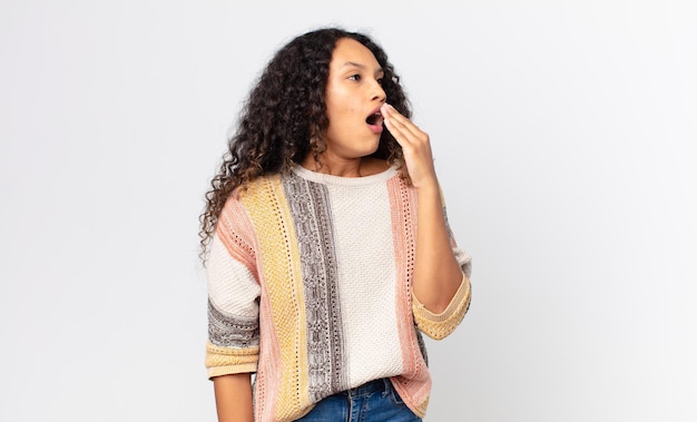 Pretty hispanic woman yawning lazily early in the morning, waking and looking sleepy, tired and bored