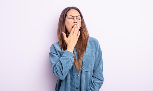 Pretty hispanic woman yawning lazily early in the morning, waking and looking sleepy, tired and bored