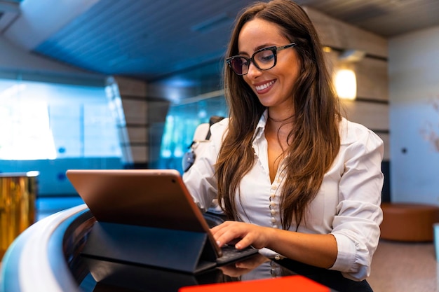 Pretty hotel receptionist smiling checks your reservation