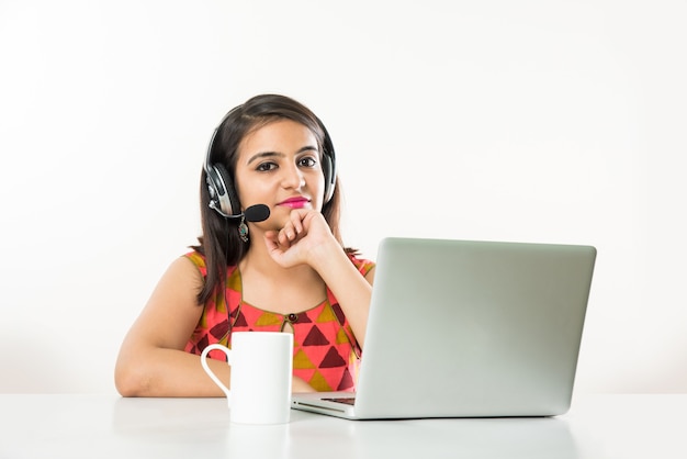 예쁜 인도 아시아 소녀, BPO 또는 콜센터 직원이 탁자 위에 노트북을 들고 헤드폰으로 이야기