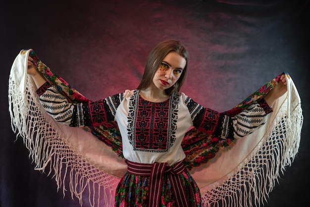 Pretty lady in ukrainian national clothes with a headscarf isolated on dark background