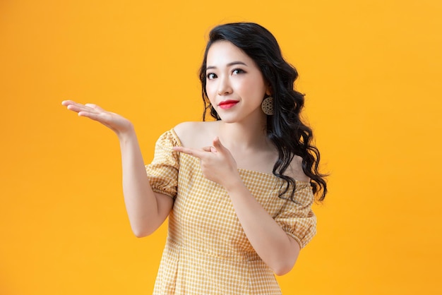 Pretty lady with casual dress looking camera with smile in studio advertising for product