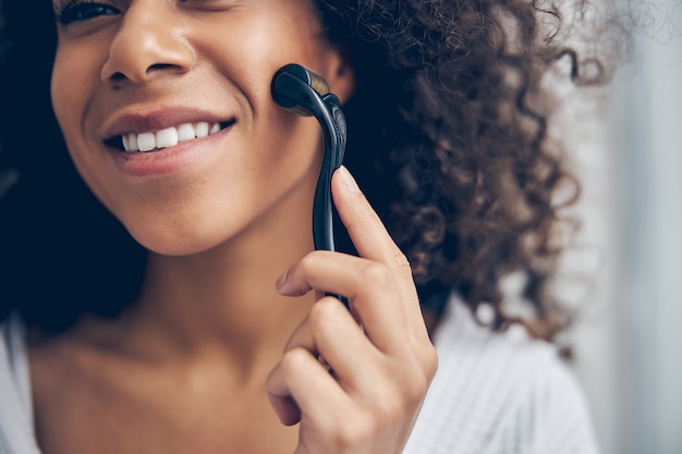 pretty lady with a dreamy expression giving herself a facial massage