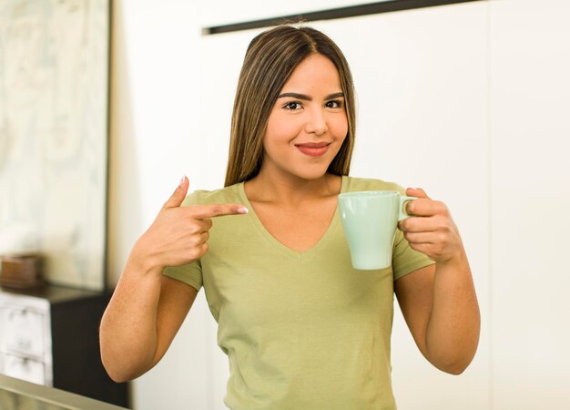 家でコーヒー カップを持つかなりラテン女性