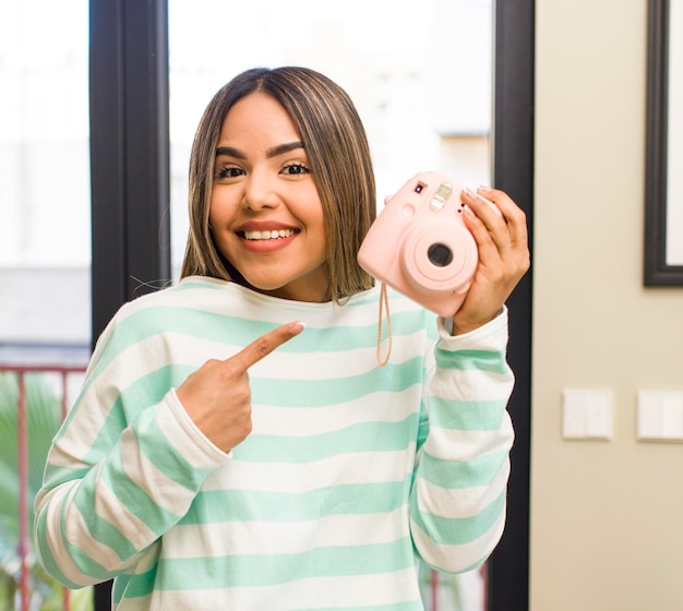 Pretty latin woman using a photography camera at home