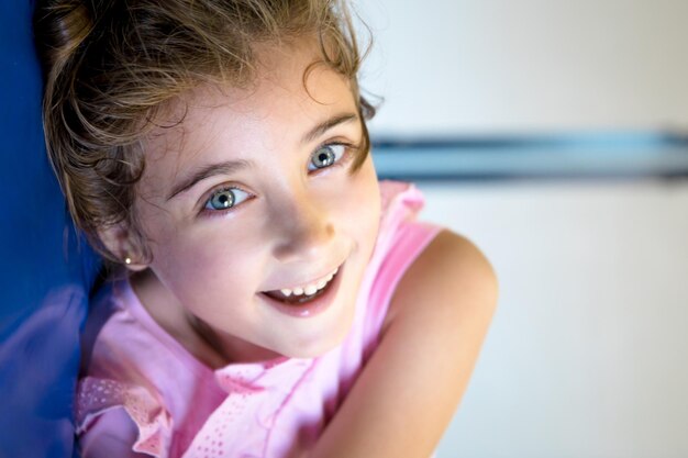 Pretty, light-eyed girl lying on mats in her school gymnasium.