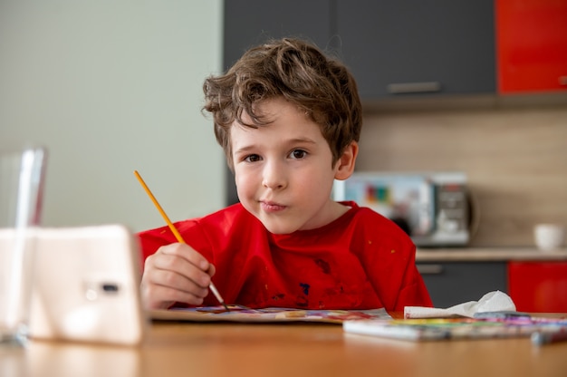 Pretty little boy drawing at home distance lessons