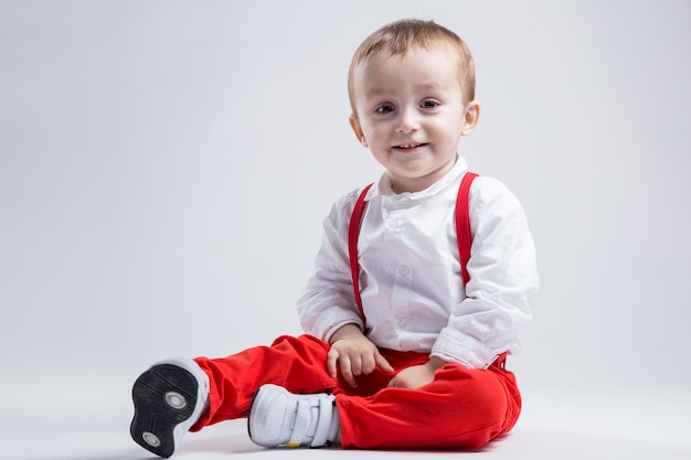 Pretty little boy, dressed in red. Boy and childhood concept.