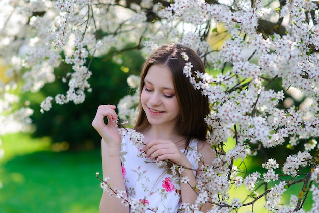 Pretty little girl in blooming apple tree garden on beautiful spring day