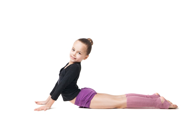 Pretty little girl doing gymnastics over white background