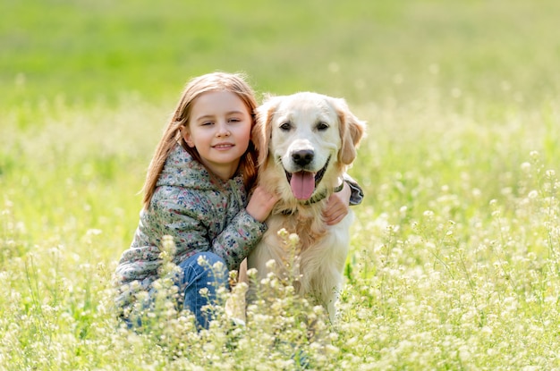 Pretty little girl embracing cute dog